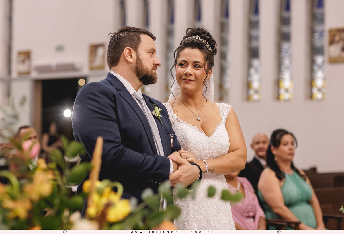 noivos se olhando em frente ao altar da igreja