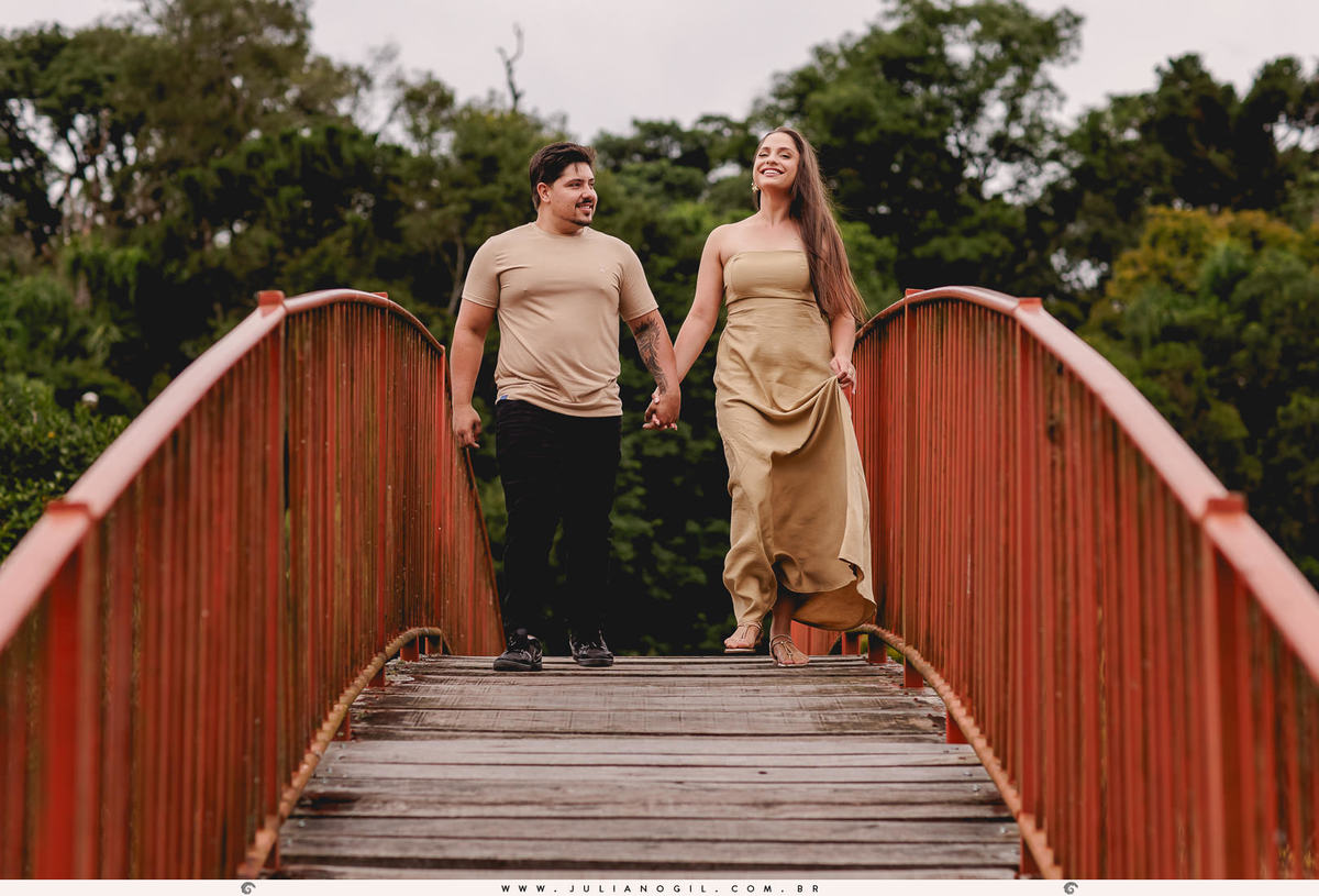 casal andando sobre uma ponte vermelha