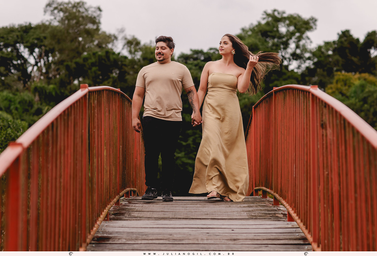 casal andando sobre uma ponte vermelha