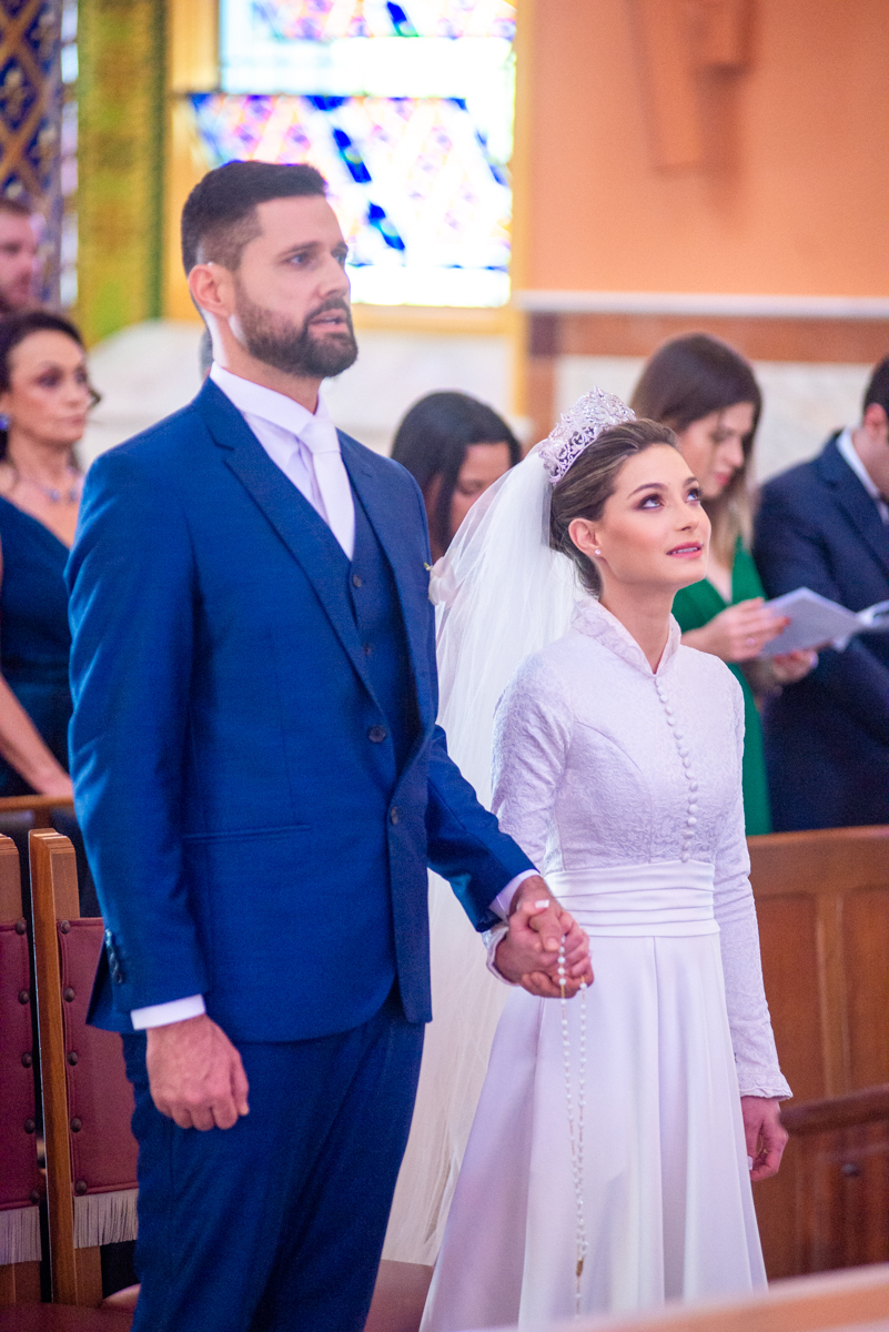 Noivos de mãos dadas em seu casamento.