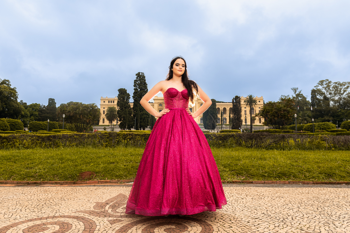 Como uma diva, a debutante posa em frente às majestosas portas do Museu, exibindo a grandiosidade de seu vestido de gala.