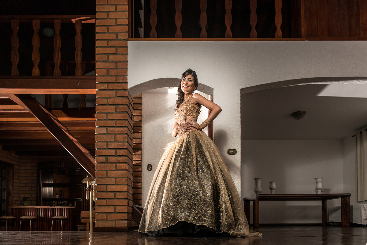 debutante pousando com seu vestido dourado