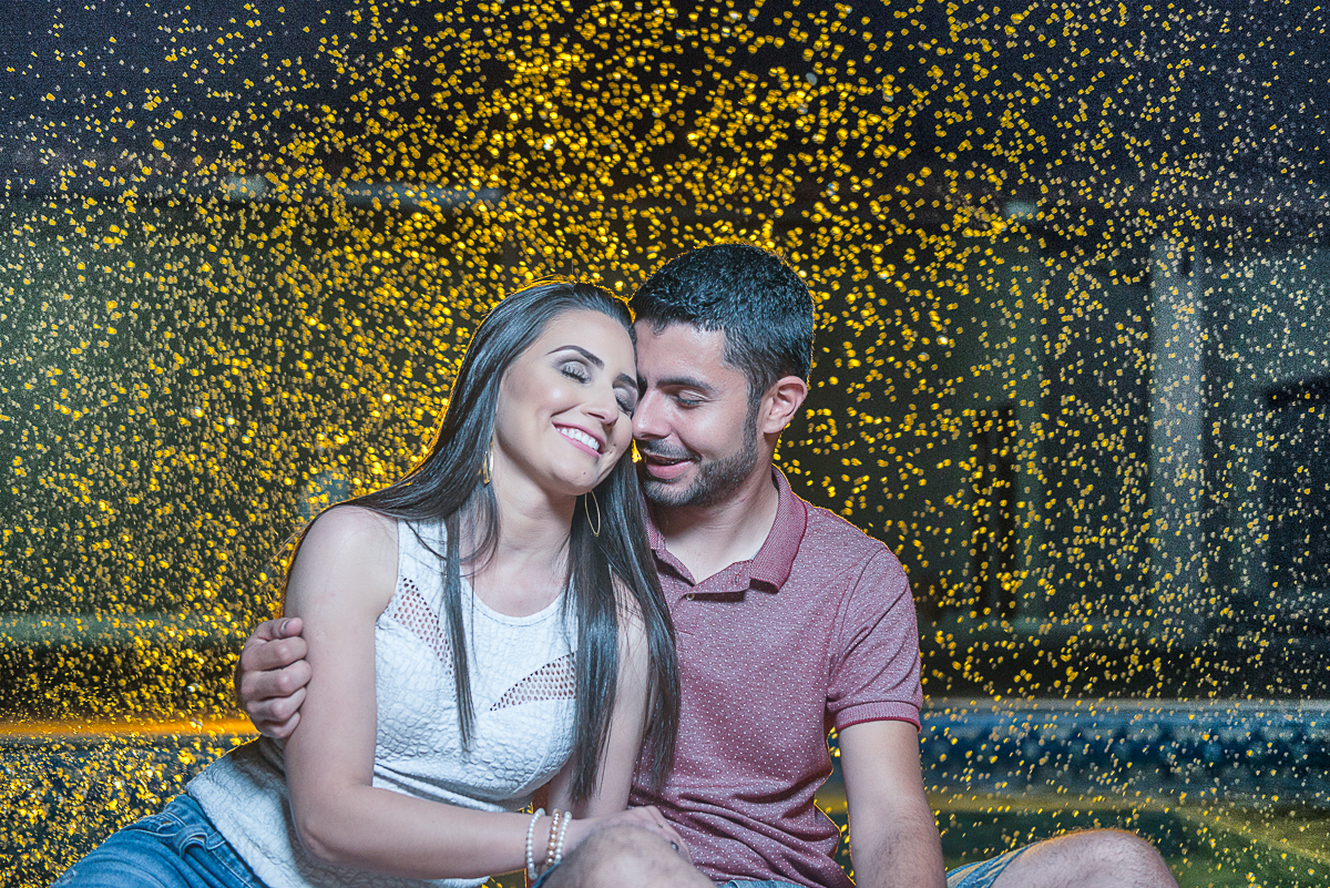casal sentado e uma chuva de água colorida