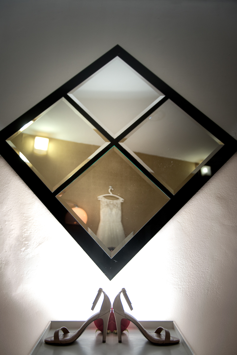 Sapato da noiva com luz de flash e vestido refletido no espelho