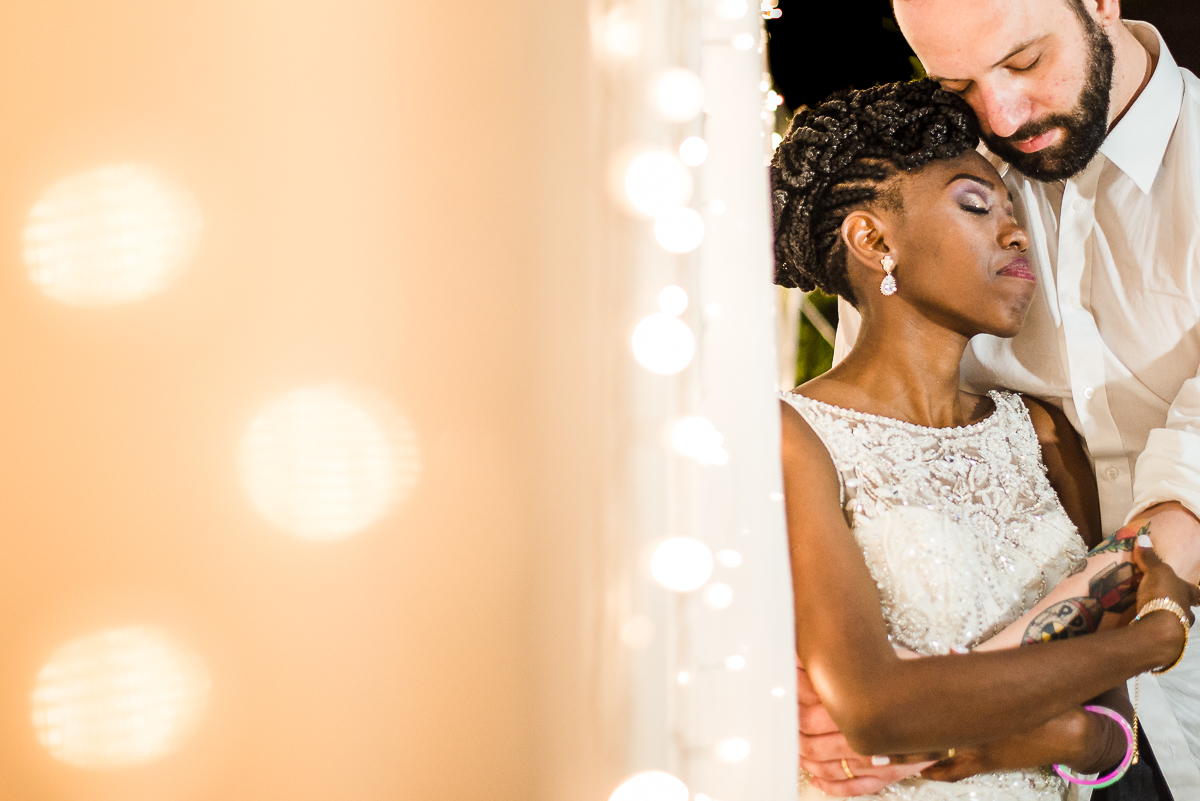 casal de noivos pousando com luzes de natal