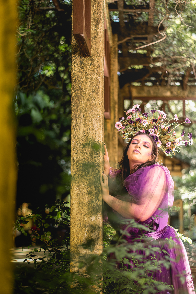 modelo com flores na cabeça pousa para fotógrafo no parque