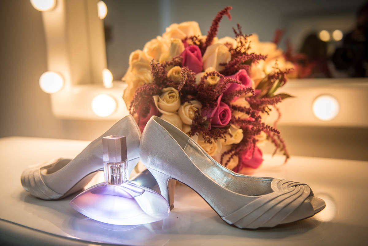 Sapato da noiva e buquê com o lindo frasco de perfume.