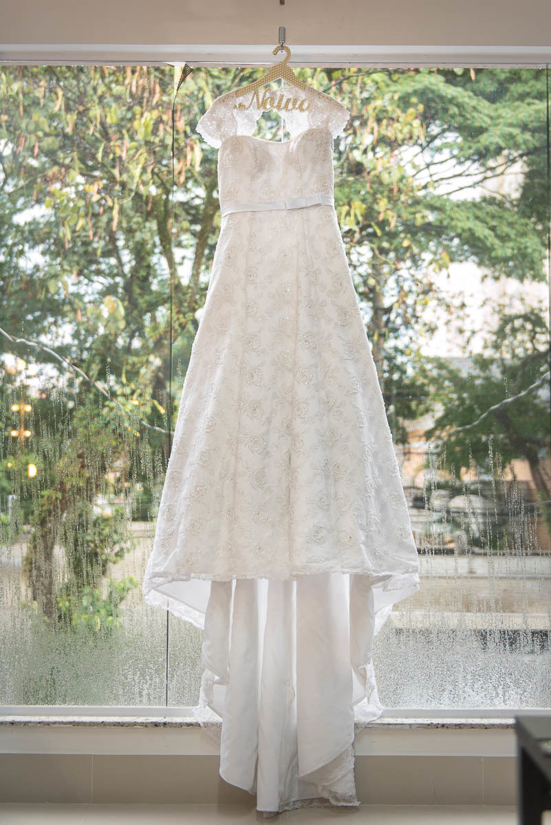 Vestido da noiva fotografado com a paisagem ao fundo do vidro do salão de beleza