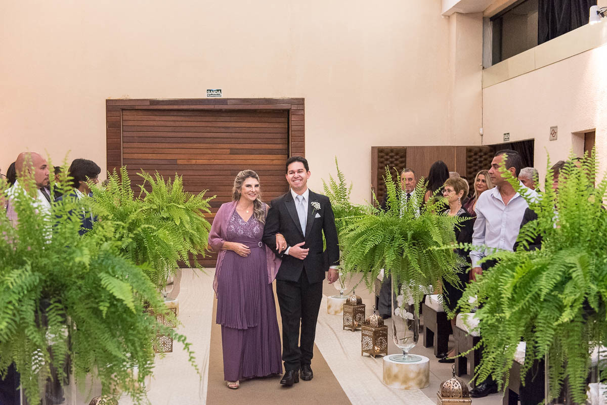 Noivo entrando com sua mãe no espaço ônix para se casar.
