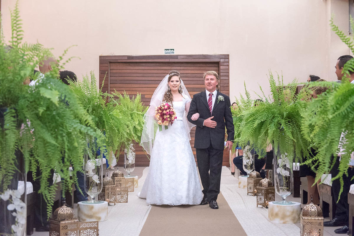 Noiva e seu pai caminhando para o altar.