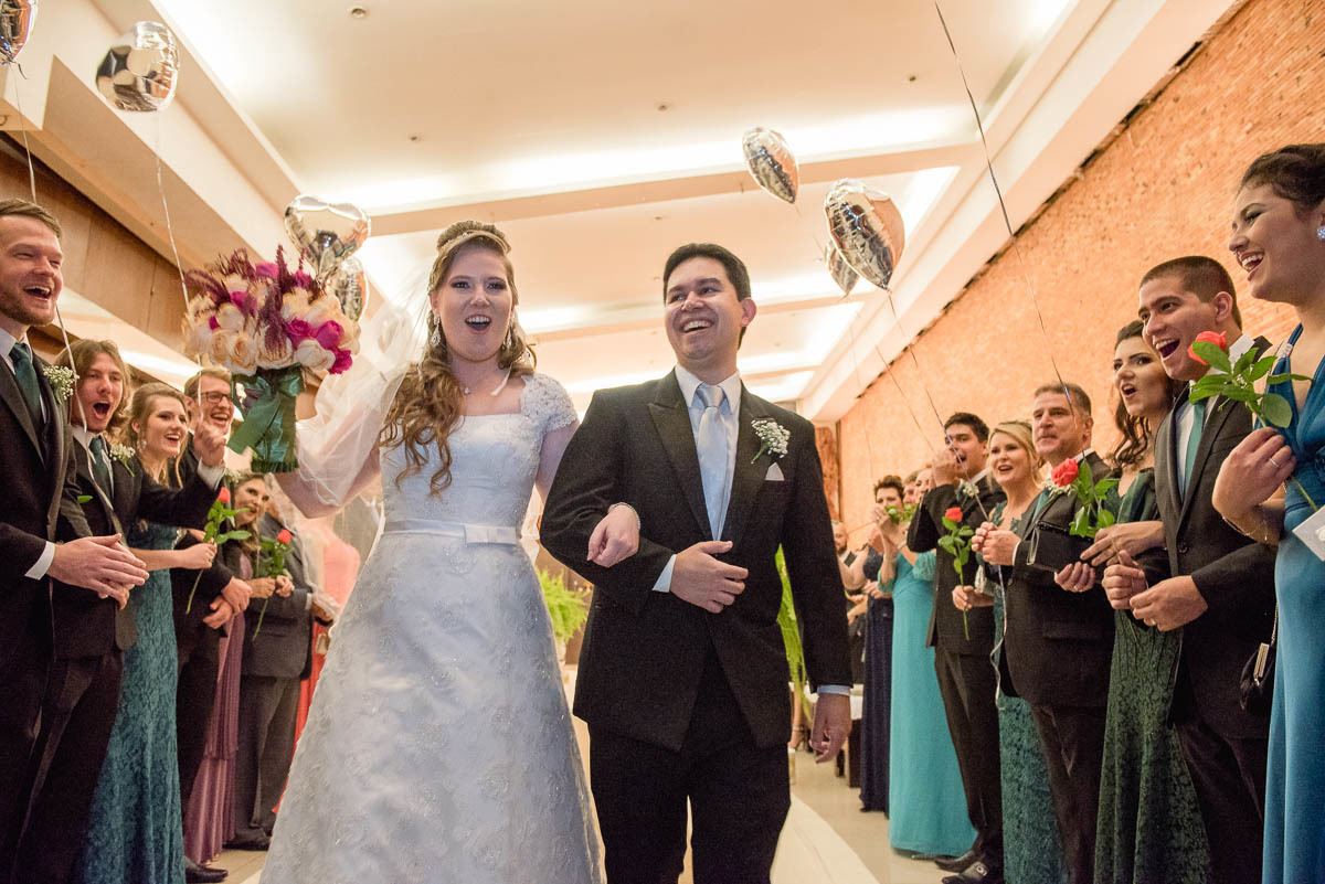 Noivos saem em grande estilo na porta do salão de casamentos.