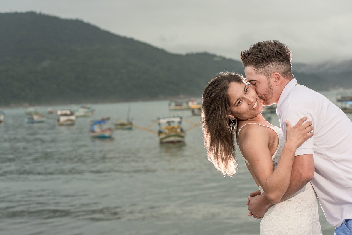 Mar, barcos, e casal em ensaio fotográfico sensacional na praia de Perequê.