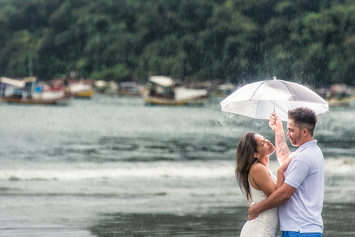Ensaio de casal na chuva na praia de Perequê, veja as gotas de água no guarda-chuvas