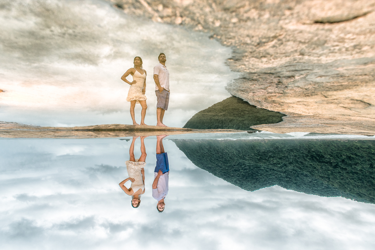Casal pousa para fotografia em ensaio de pre wedding e fotógrafo capta o reflexo dele na poça d'água no chão