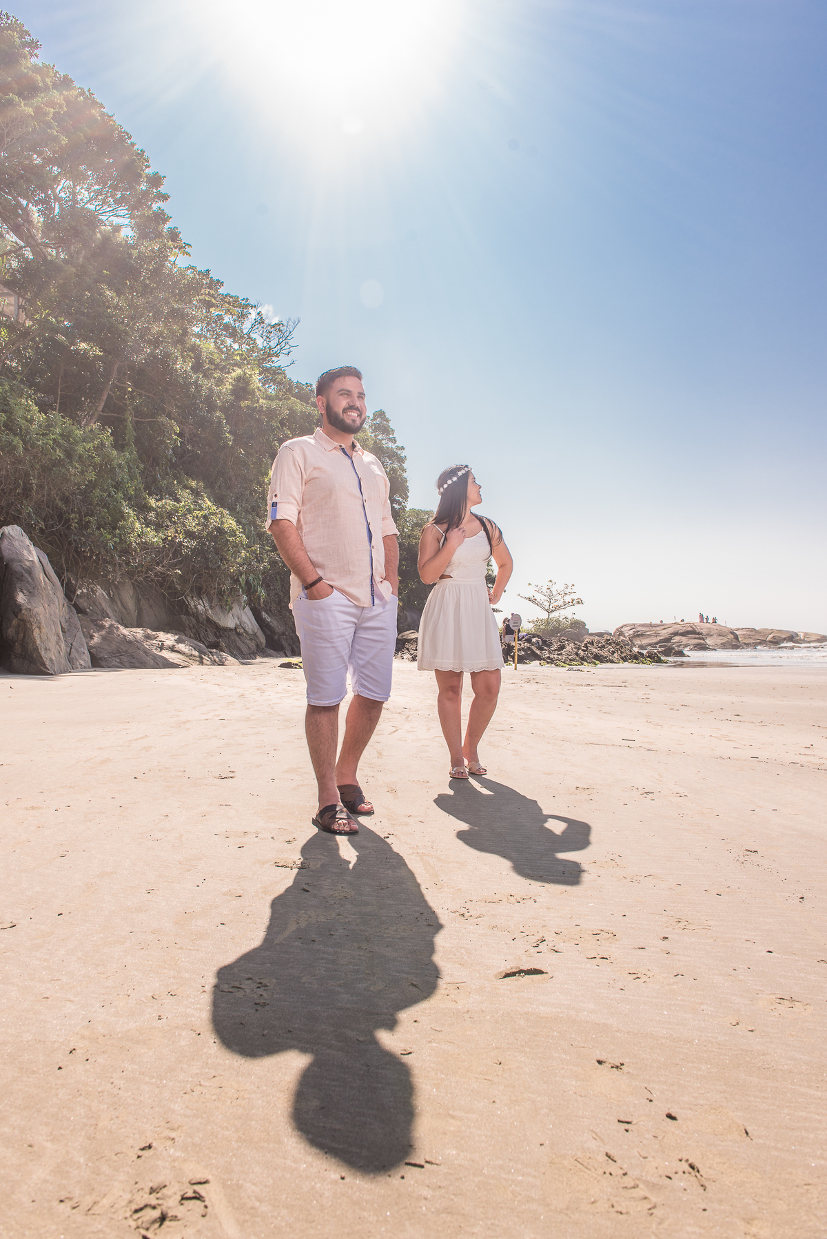 Uma bela foto do casa em ensaio pre wedding com o céu azul na praia no Guarujá.
