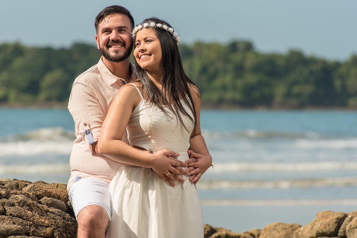 Casal feliz fazendo poses de ensaio para sessão pre casamento com o fotógrafo Alberto Martinez na praia de Iporanga no Guarujá.