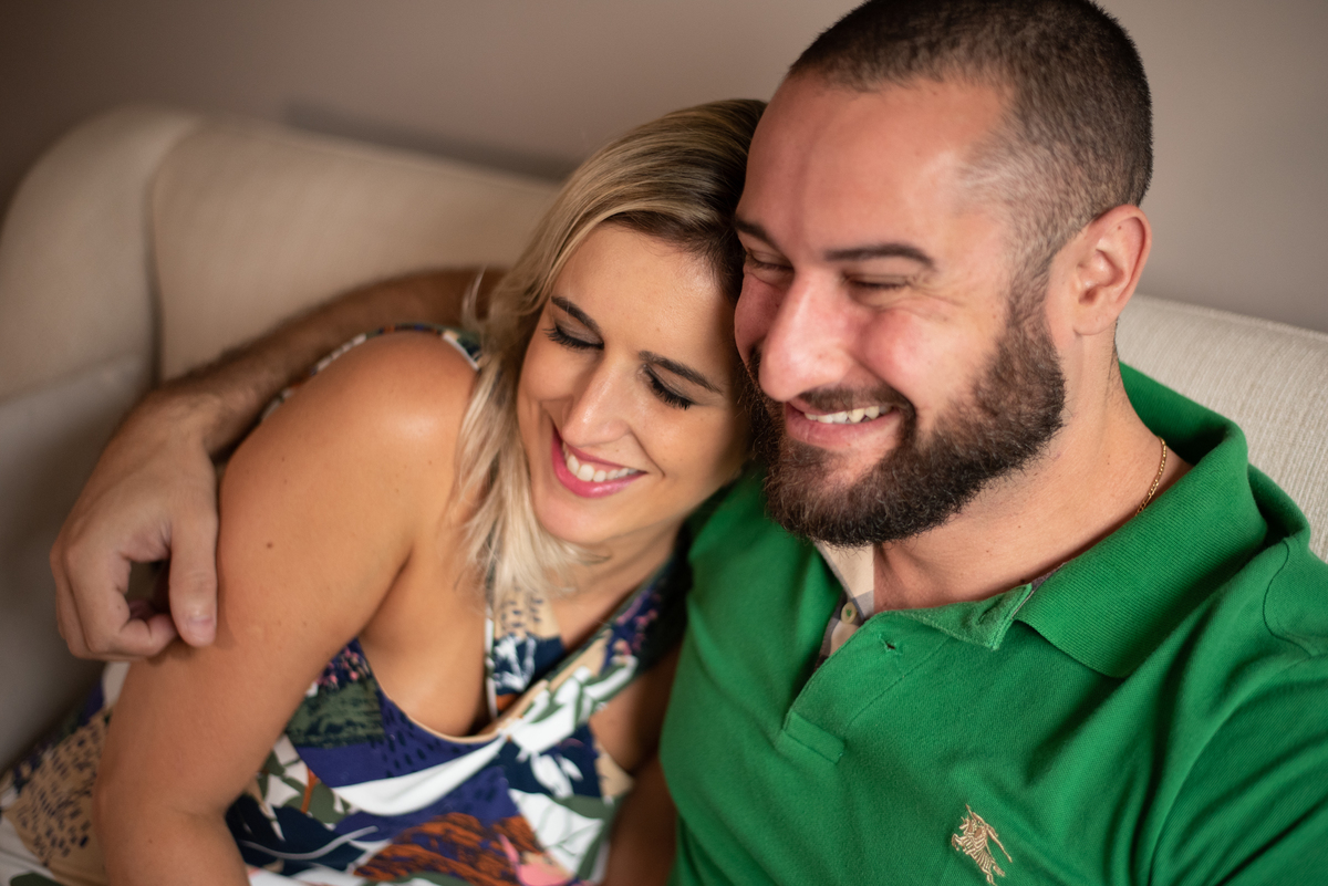 No aconchego de um sofá que tem história para esse casal, fotógrafo pega momentos de descontração em ensaio do casal.