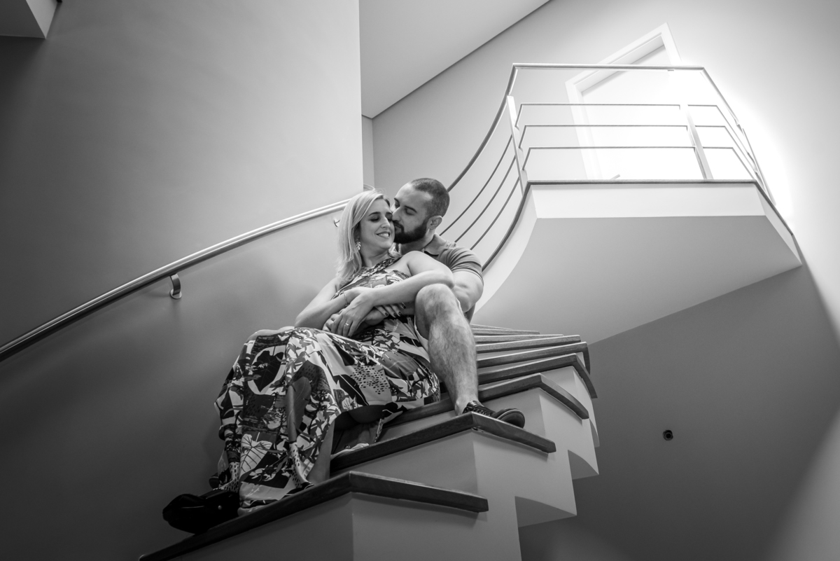 Casal sentado na escada faz linda foto com uma luz incrível neste ensaio sensacional de pré casamento.
