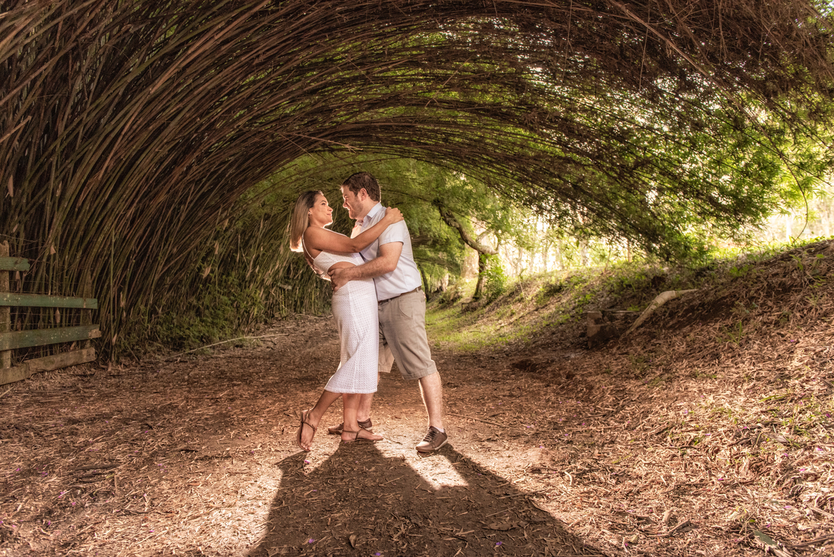 Fotografia do casal feita sob uma onda de bambus que faz um efeito interessante na fotografia de pré wedding feita no parque Cemucam.