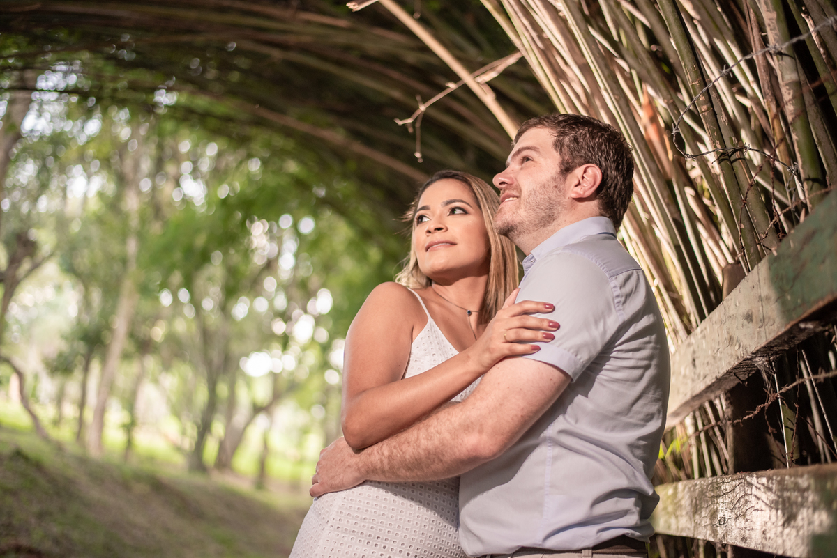Casal olhando para o infinito em abraço aconchegante na cerca do parque Cemucam.