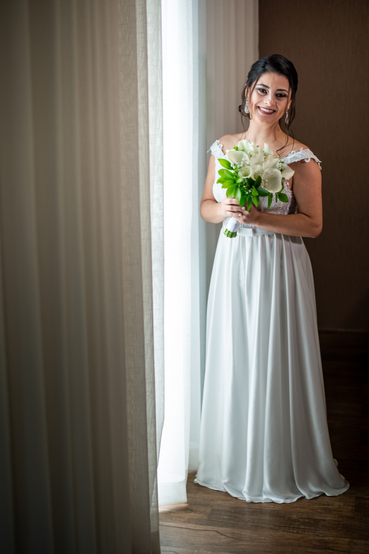 Noiva na janela do quarto de sua casa olhando os convidados chegar.