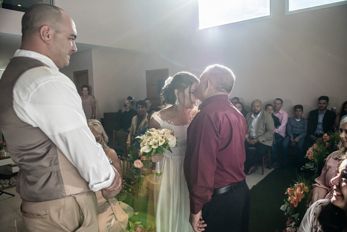 Pai da noiva dá um beijo na testa da filha antes de entregar para o noivo.