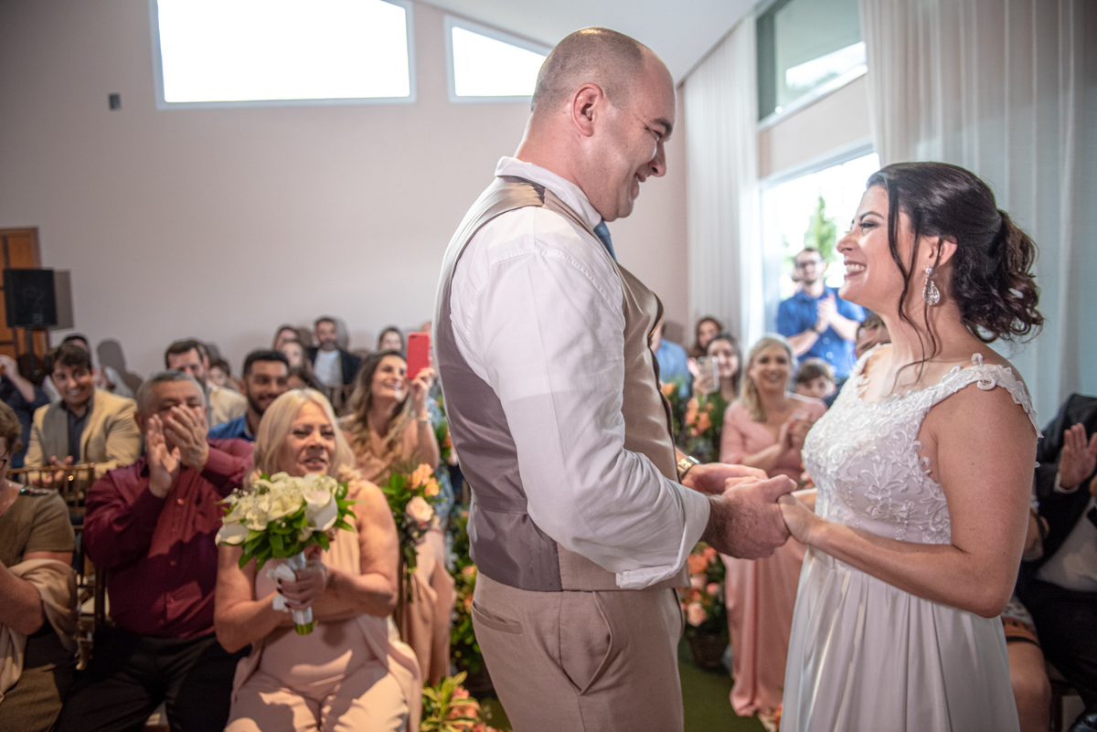 Noivos se olham apaixonados em cerimonia de casamento civil.