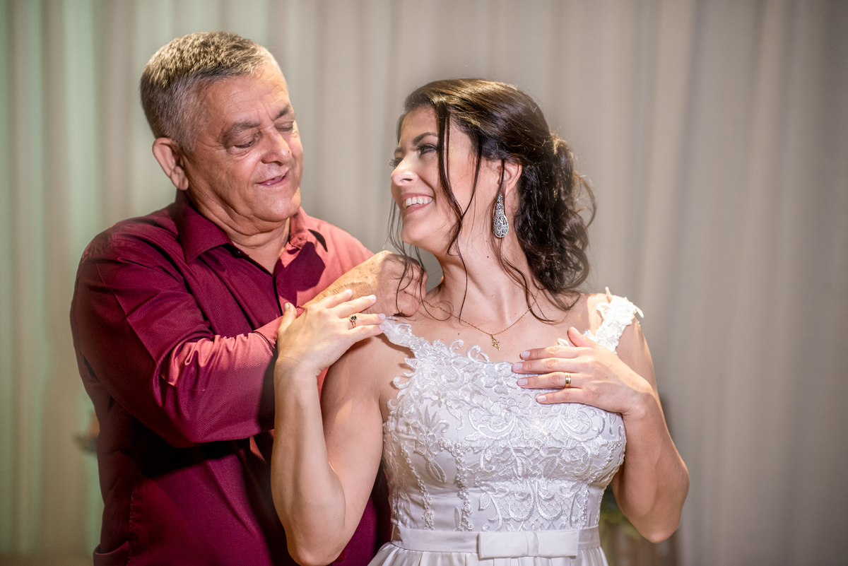 Pai entrega um colar de ouro para noiva e sua filha.