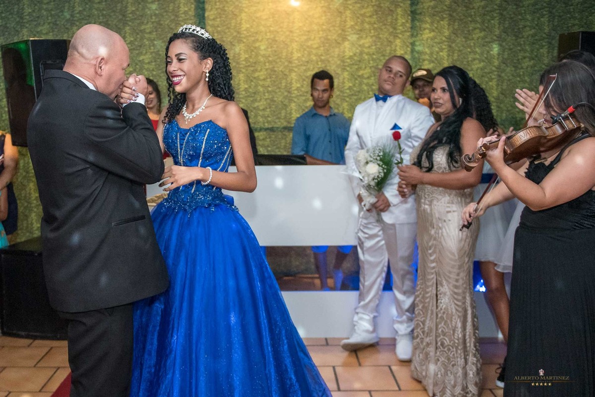 Pai beija a mão da filha na festa de debutante na casa acoty