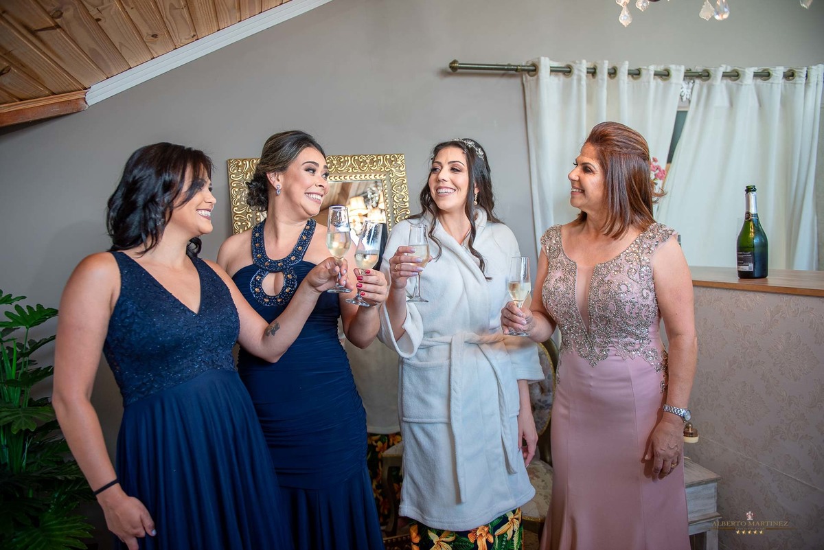 Noiva com a mãe e madrinhas fazendo um brinde