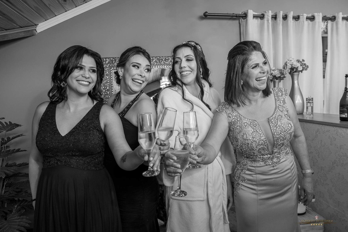 Noiva com a mãe e madrinhas fazendo um brinde