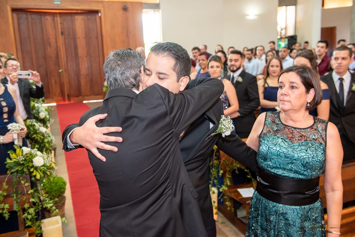 Noivo abraçando o pai na igreja na cerimonia de casamento