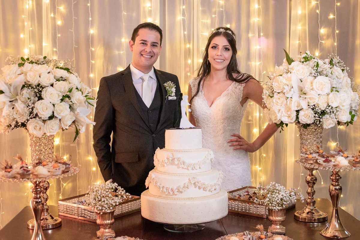 Noivos em frente do bolo de casamento no buffet sonata