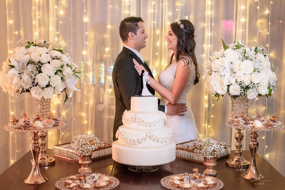 Noivos em frente do bolo de casamento no buffet sonata