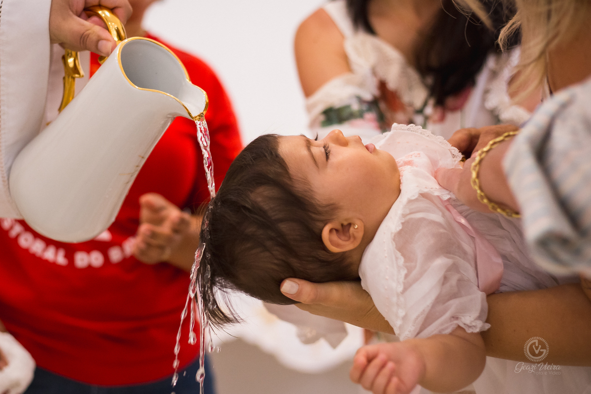 Criança sendo batizada pelo padre
