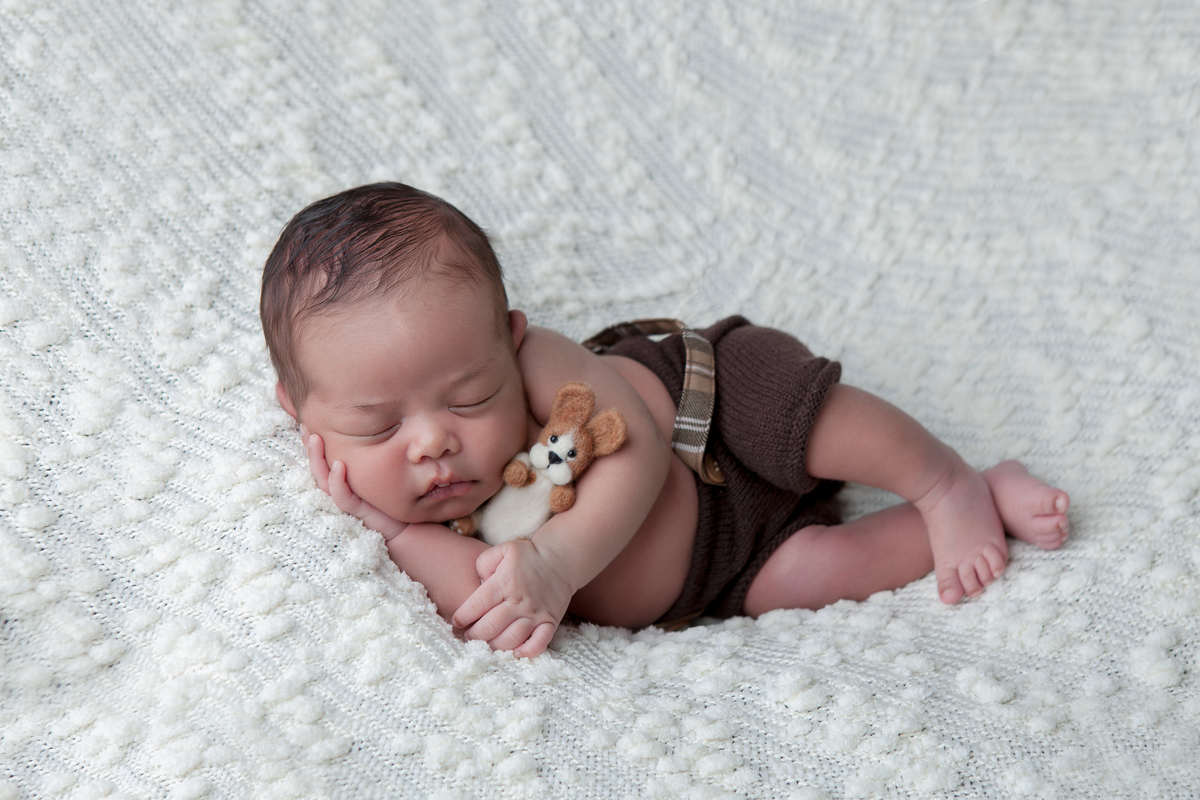 Fotografia de bebê newborn de lado, realizada no Estúdio Fotográfico Rosi Lima Fotografia, localizado na região do Barreiro, cidade de Belo Horizonte -  MG