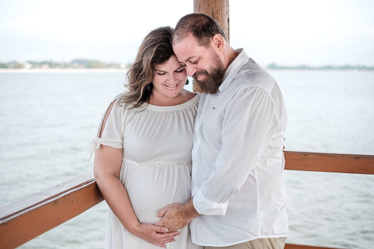 casal abraçado a espera da filha olhando para barriga