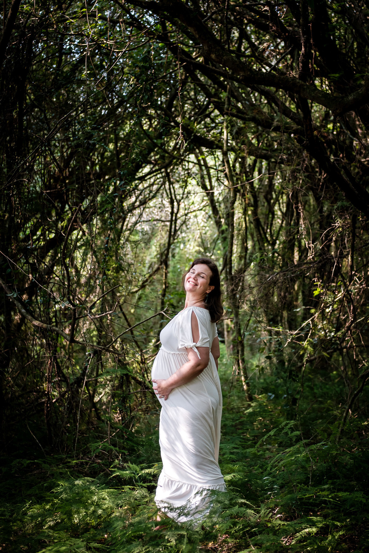 mulher gestante sorrindo na floresta 