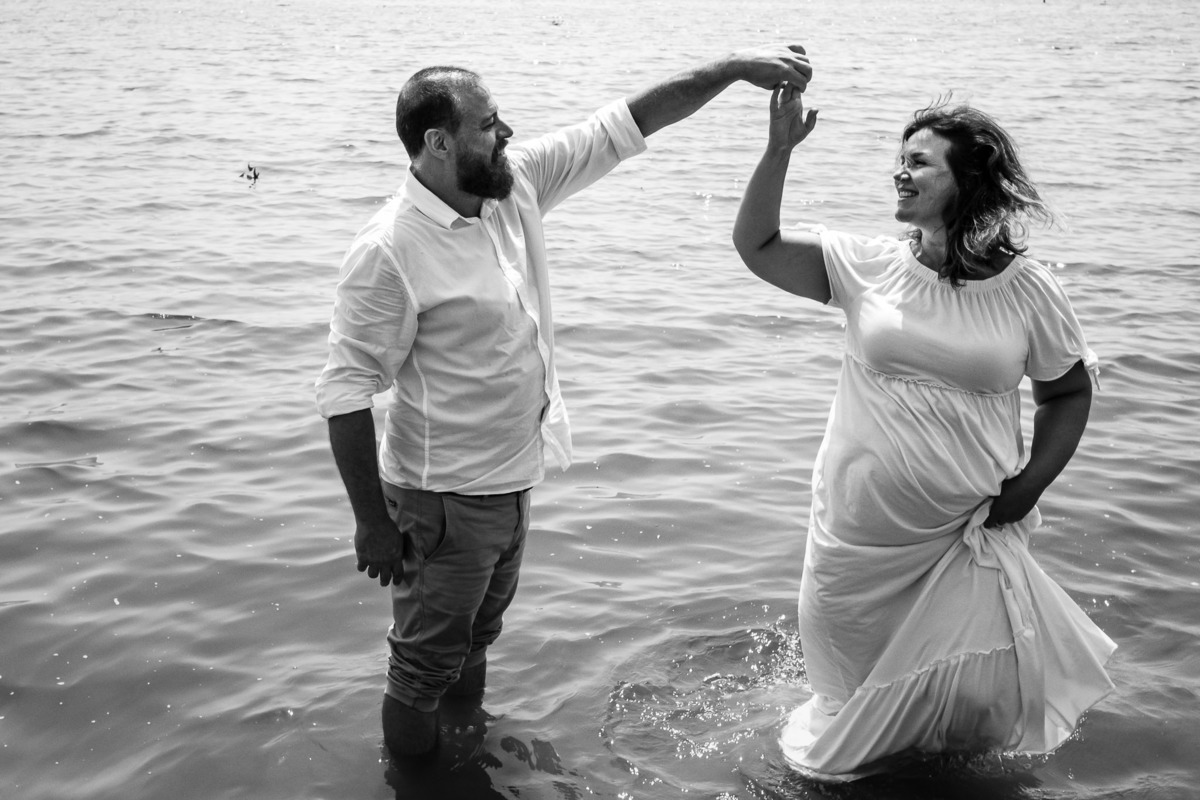 casal dançando e sorrindo na água 