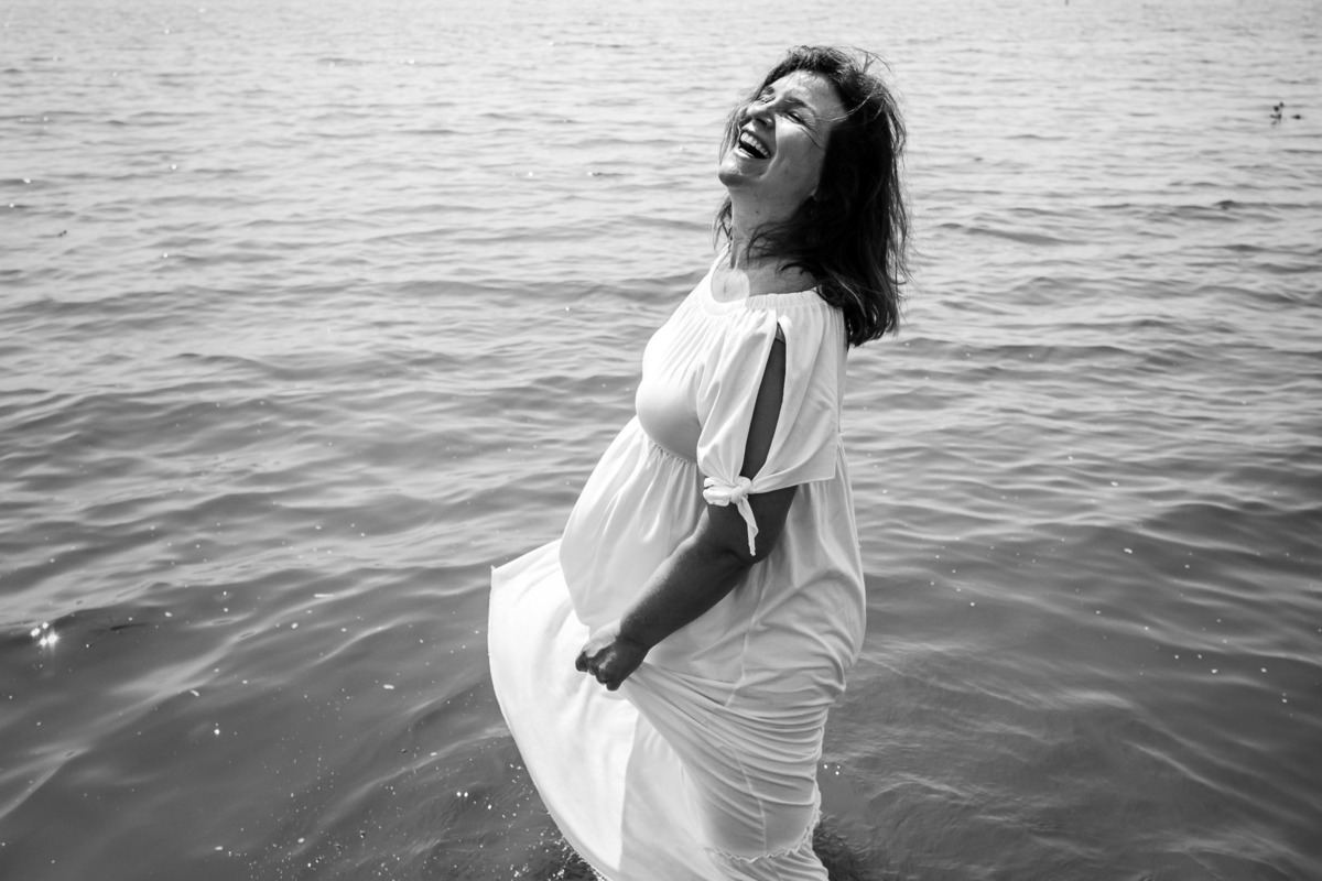 mulher dançando e sorrindo dentro da água