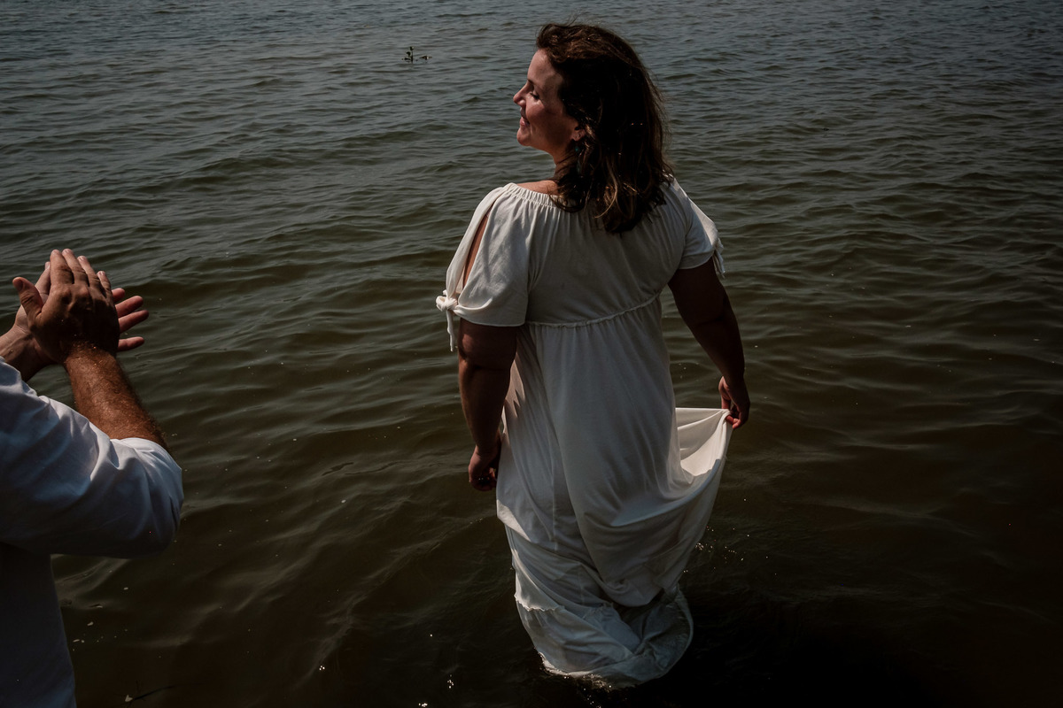 mulher dançando e sorrindo dentro da água e homem bate palmas 