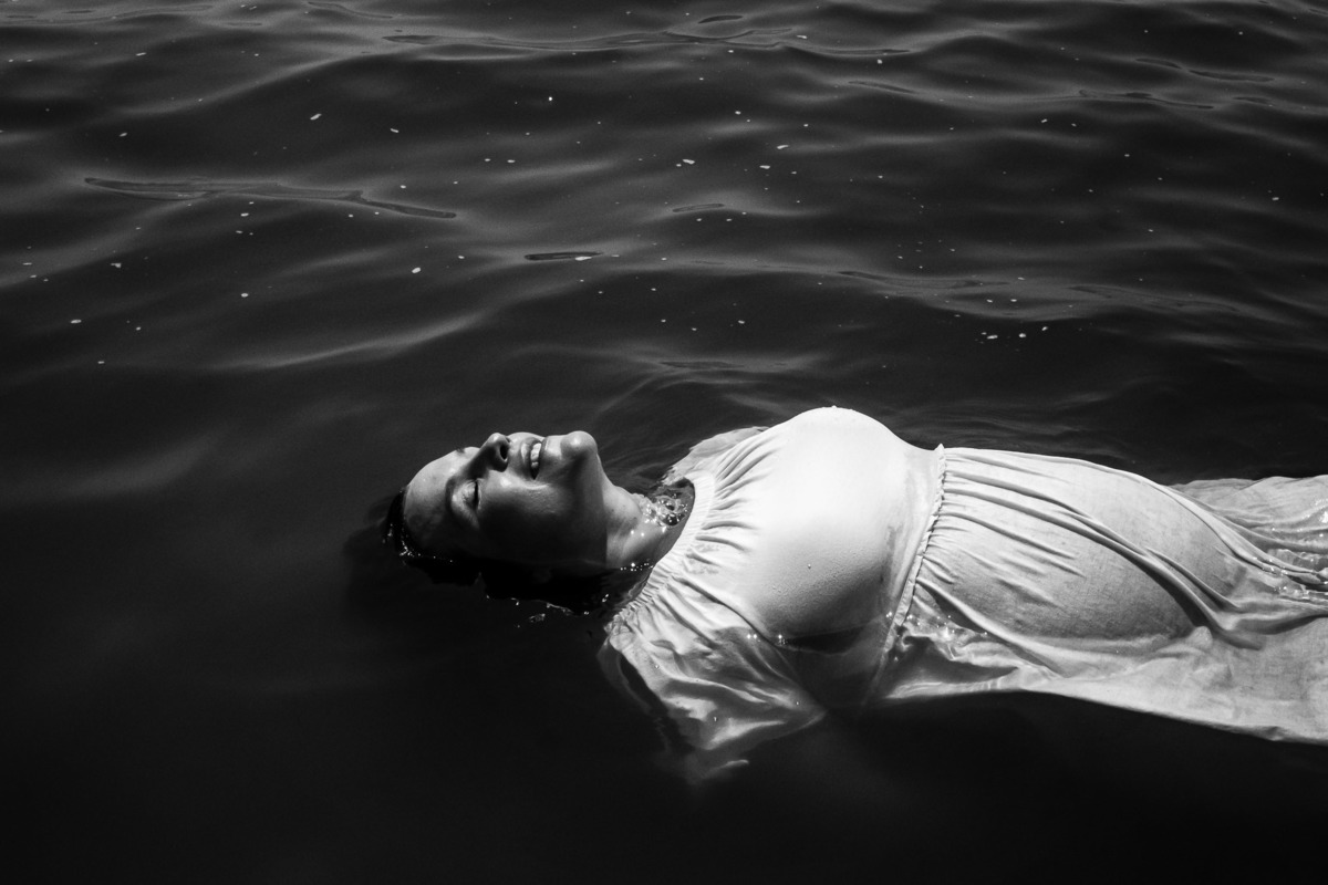 gestante boiando na lagoa iluminada pelo sol