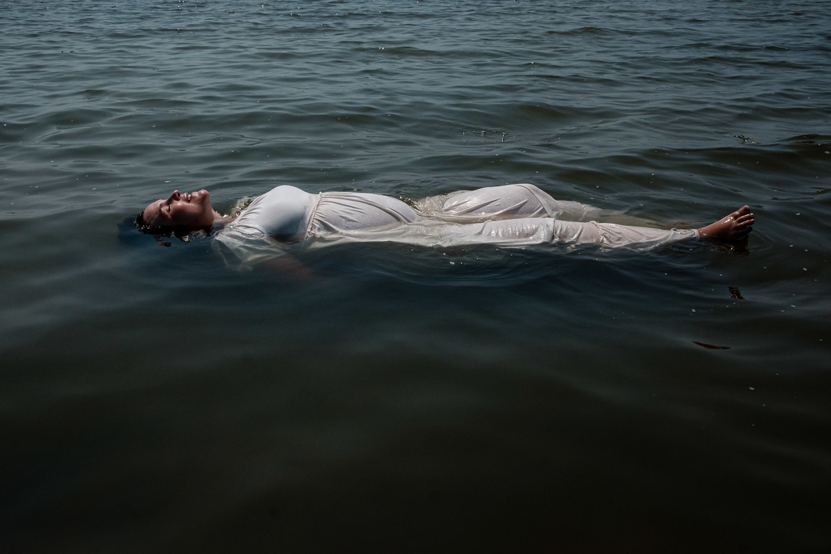 gestante boiando na lagoa e iluminada 