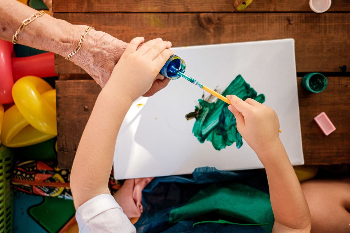 criança pintando tela com tinta
