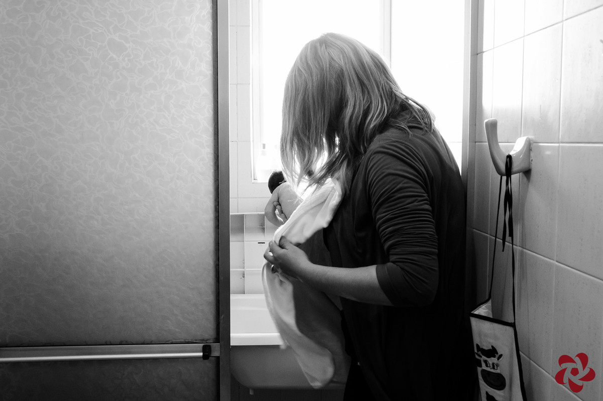 A mãe está tirando a filha recém nascida da banheira.