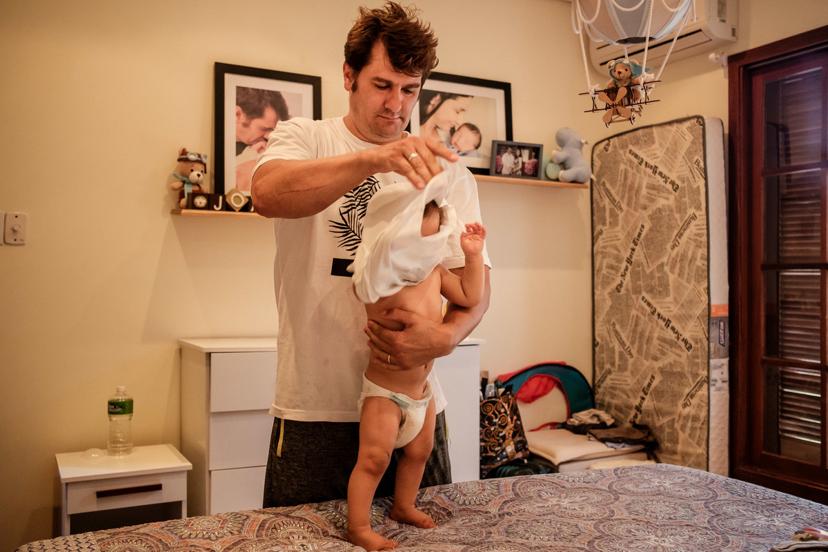 pai tirando a roupa do bebe