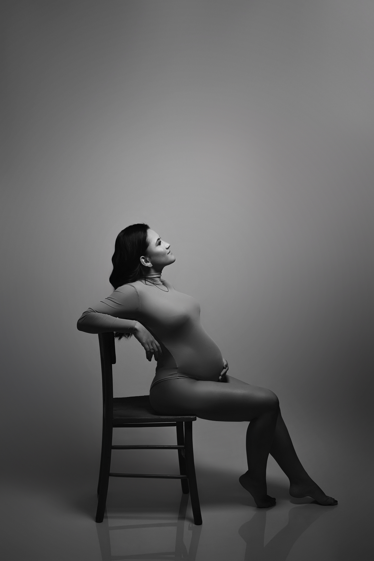 fotografia de gestante em preto e branco pose de gestante sentada look para ensaio de gestante estudio fotografico para gestante
