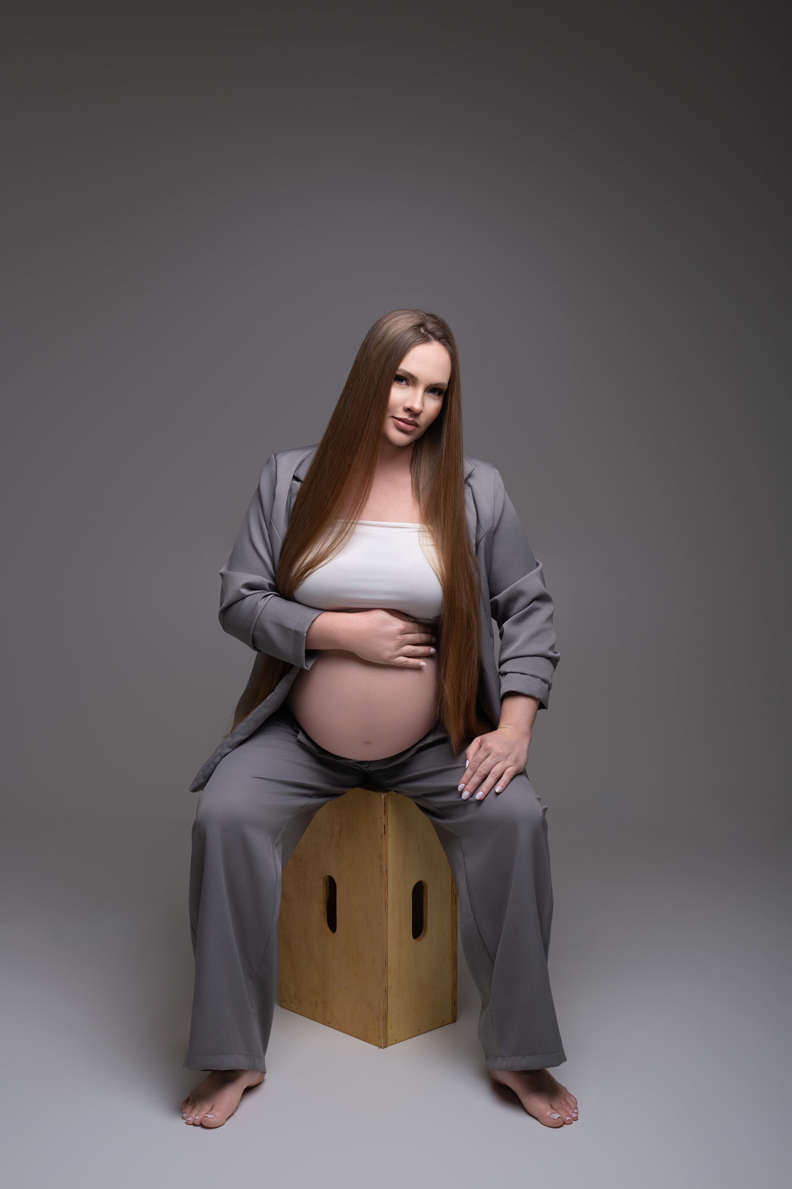 Ensaio de gestante em estúdio profissional em Maringá PR, com fotografia minimalista e sofisticada. Ensaio assinado por fotógrafa especializada em gestante, em estúdio fotográfico para gestante, look clean para gestante, blazer gestante, look gestante 