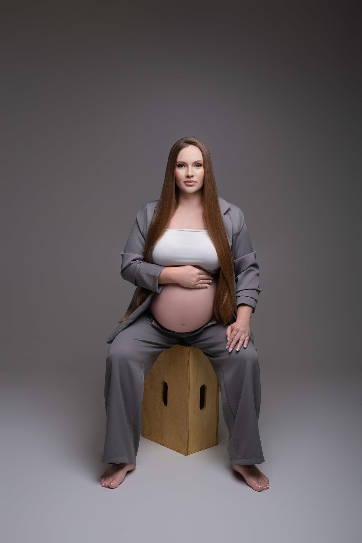 Ensaio de gestante em estúdio em Maringá PR, com fotografia clean e estética minimalista. Ensaio realizado por fotógrafa especializada em gestante, em estúdio fotográfico para gestante, com direção profissional e resultado elegante e atemporal.