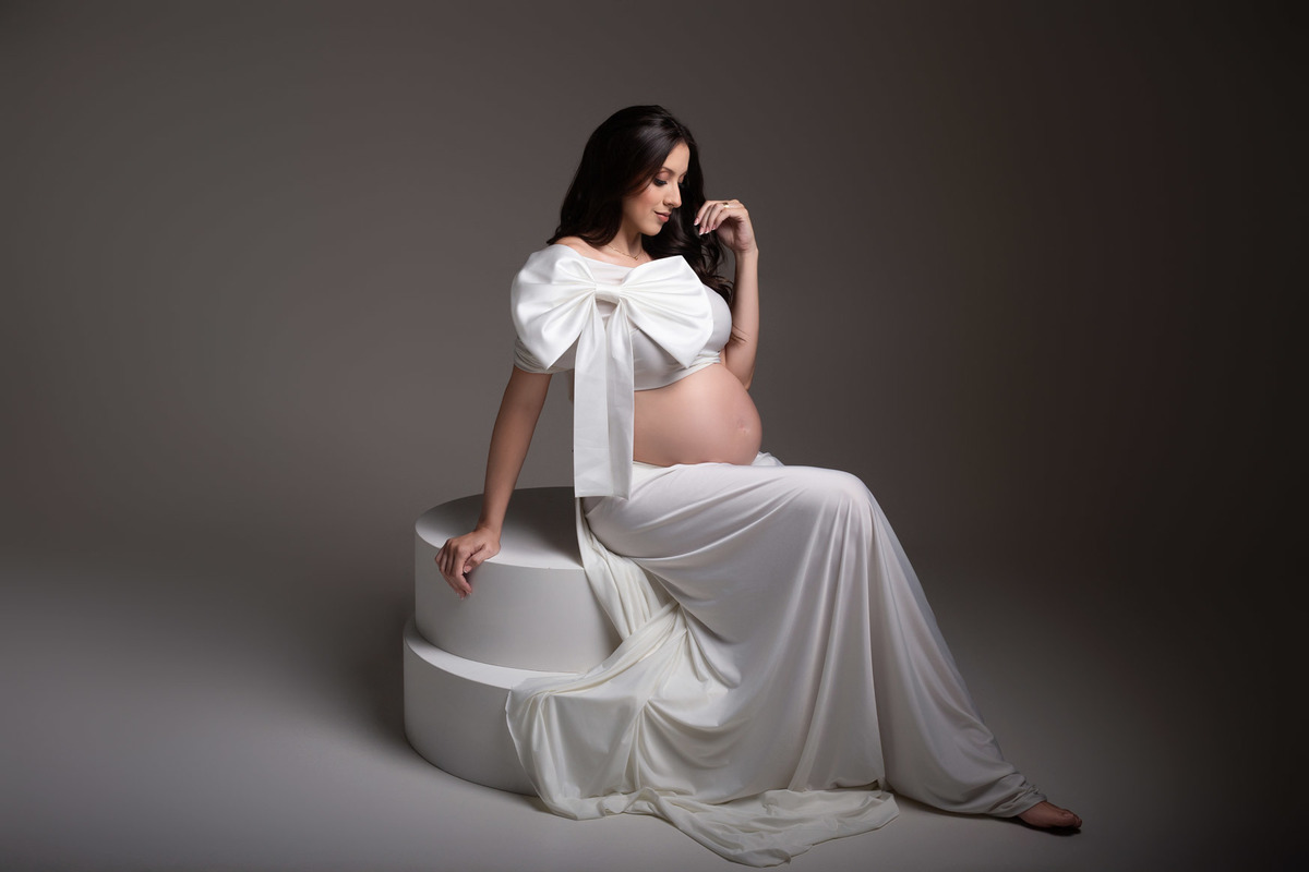 Ensaio de gestante em estúdio em Maringá PR, com iluminação suave e estética clean. Fotografia conduzida por fotógrafa especializada em gestante, em estúdio fotográfico para gestante, valorizando a maternidade com elegância e atemporalidade.